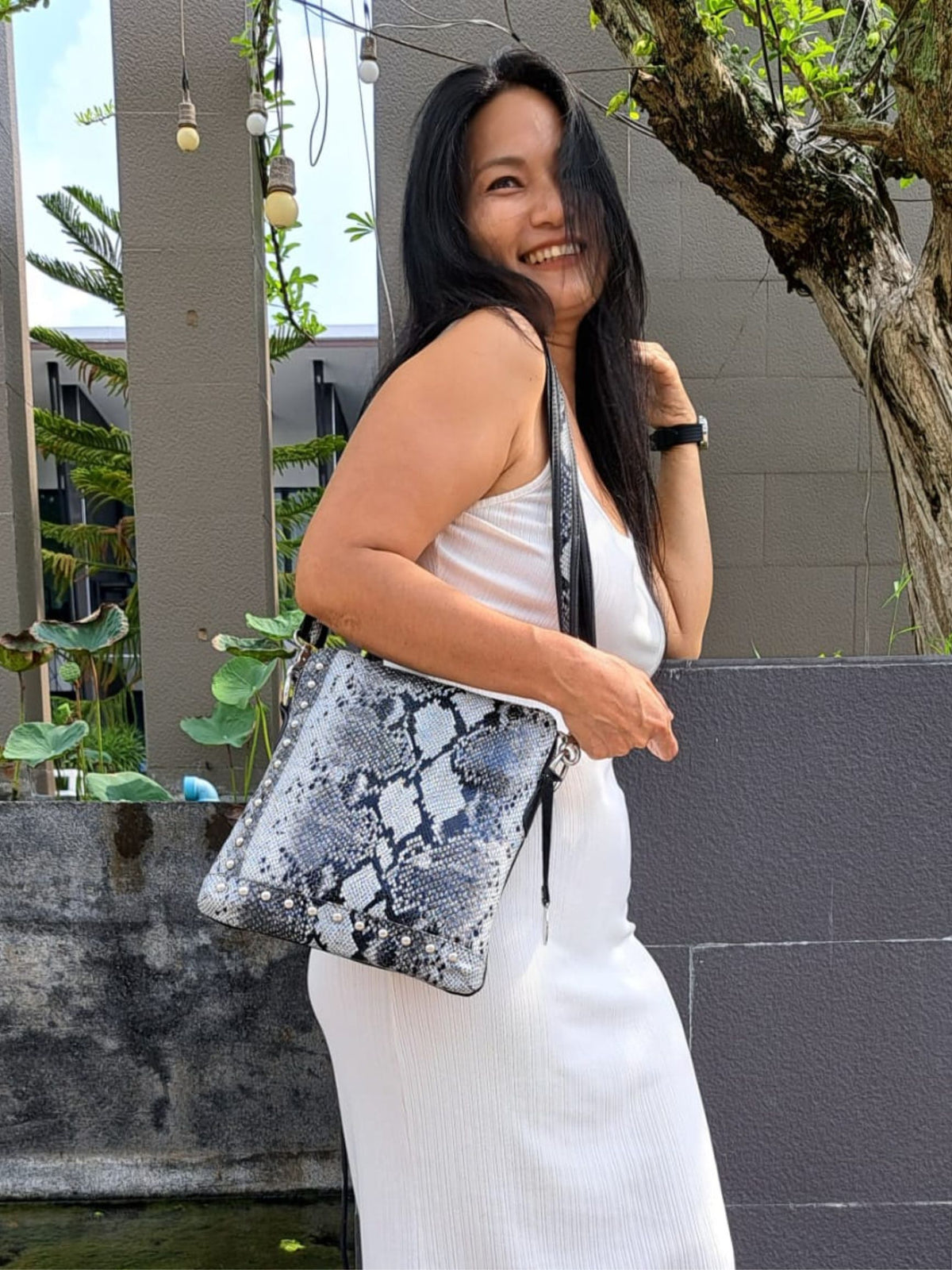 Style Quick i flot sort/hvidt slangepræget læder. Cool slingbag til skulder og crossbody m. flotte nitter